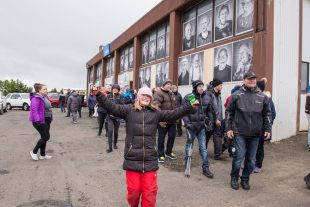 Risa andlitsmyndir af eldra fólki límdar uppá húsveggi