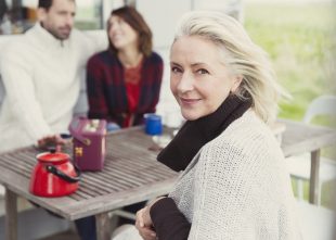 Portrait smiling senior woman at patio table