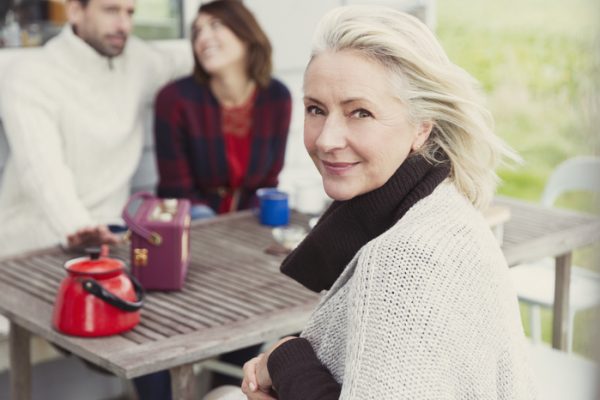 Portrait smiling senior woman at patio table